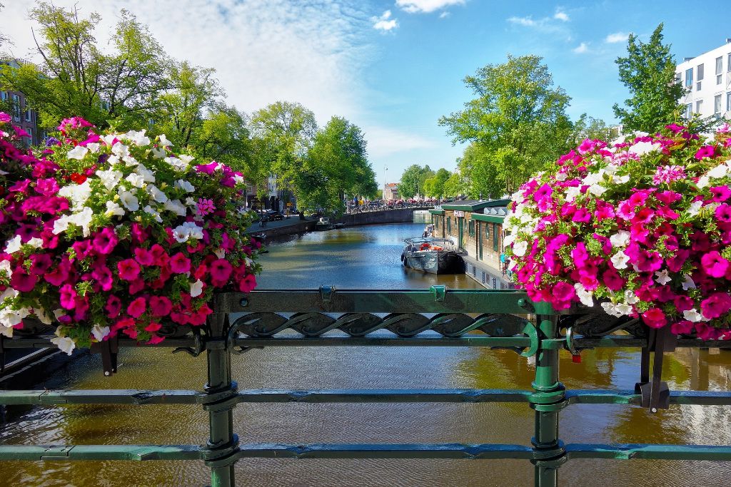 Een met bloemen versierde brug over een kanaal in Amsterdam.