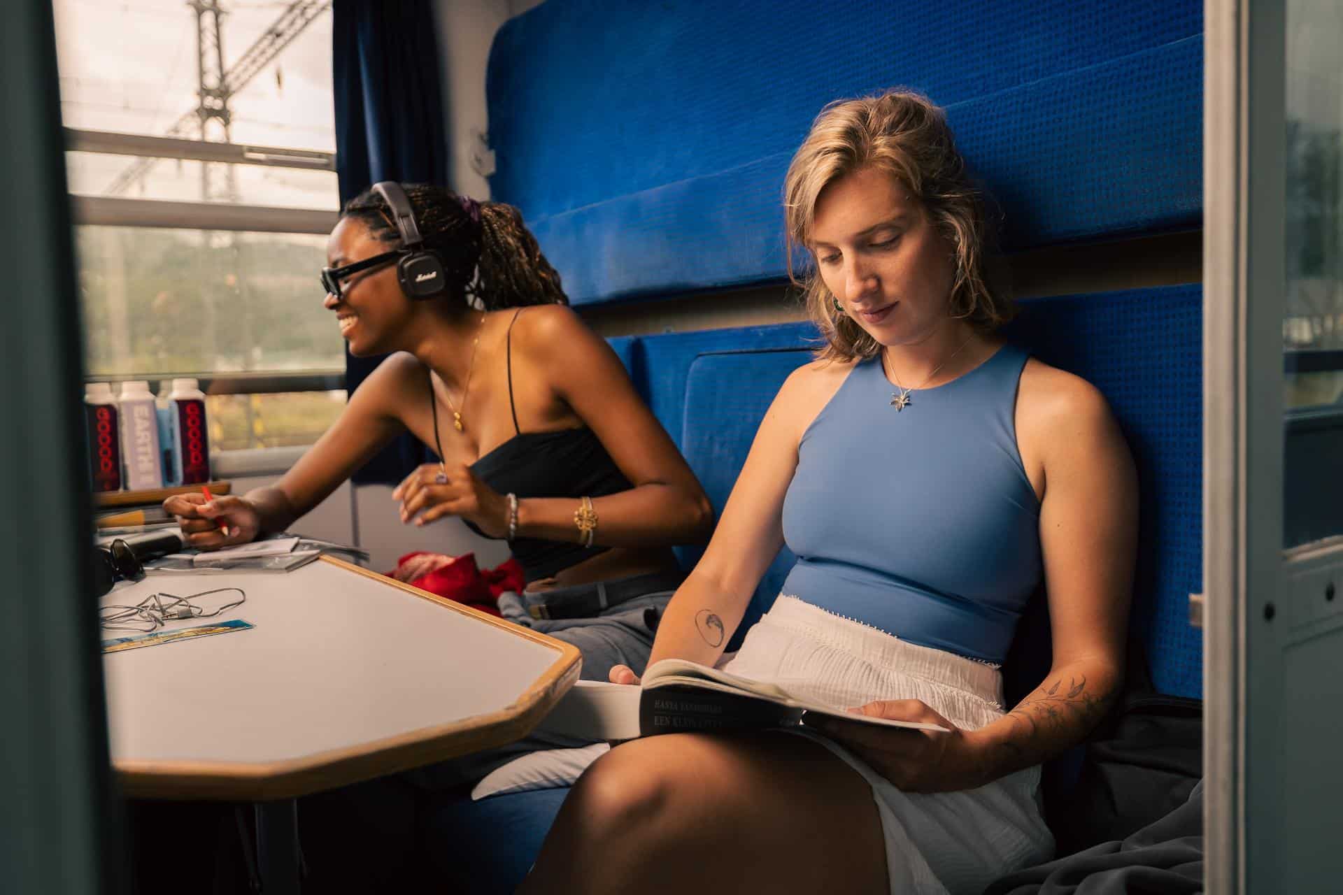 Woman reading a book in her cabin on a sleeper train.