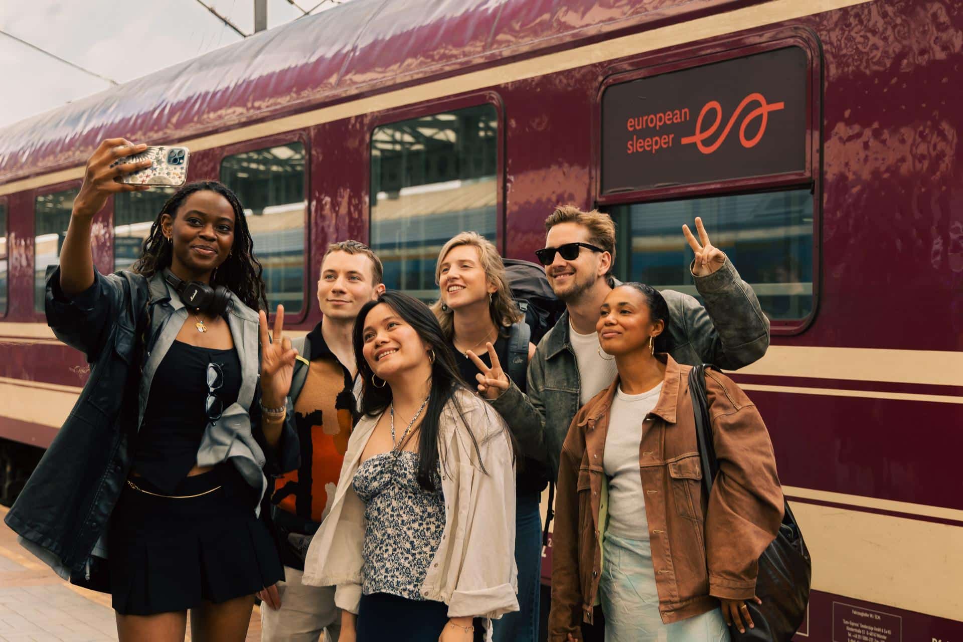 Group of friends taking a picture in front of a European Sleeper carriage.